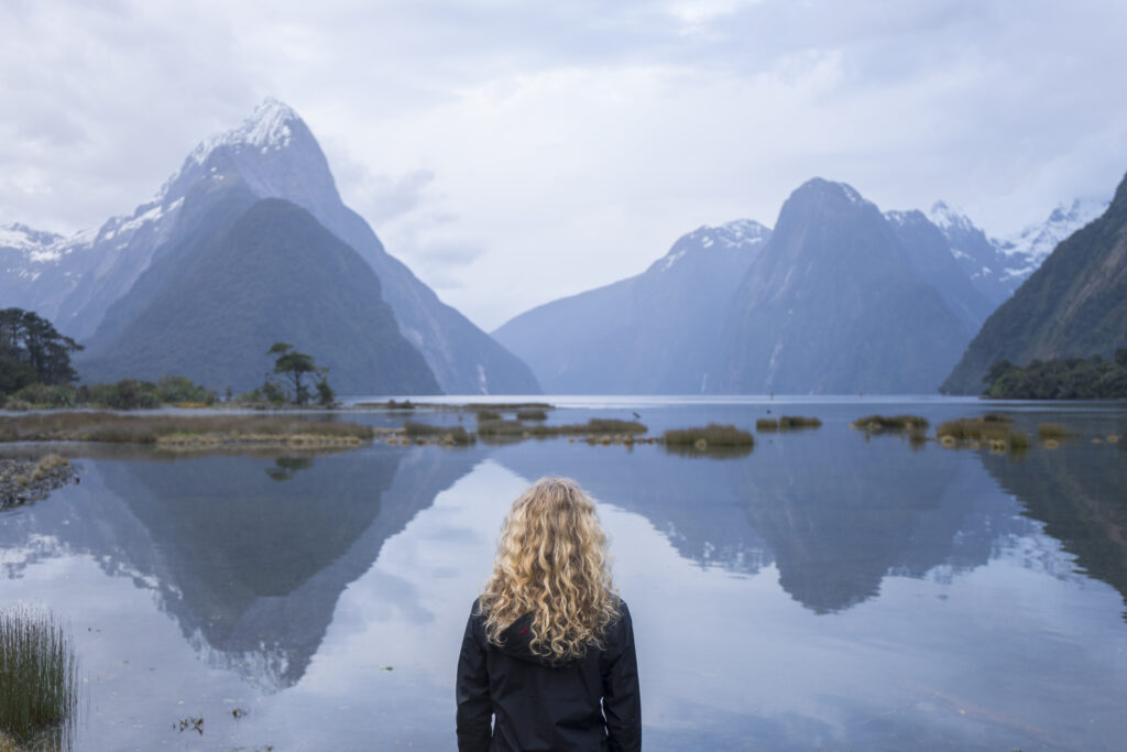 Milford Sound fiord cruise with towering cliffs and waterfalls, Fiordland National Park, New Zealand.