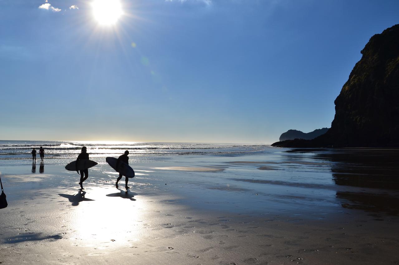 Surfers at Piha Beach
