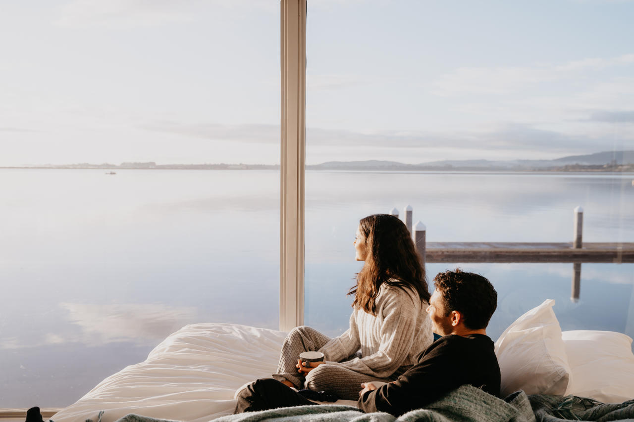 Couple admiring view in room at Trinity Wharf Hotel